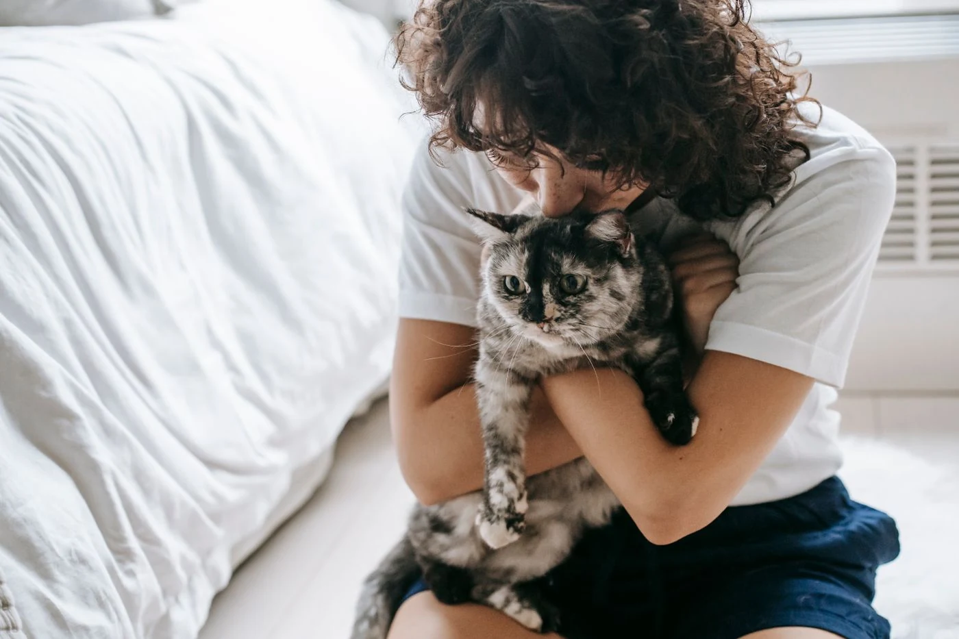 Mujer abrazando a su gato en casa